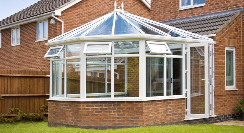 a brick house with a circular brick and glass sunroom